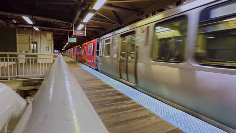 silver subway train comes to a stop at an empty station at night