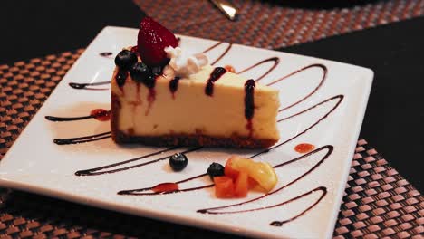 pastel de queso caramelo con fresa en un plato blanco en una mesa de restaurante de lujo