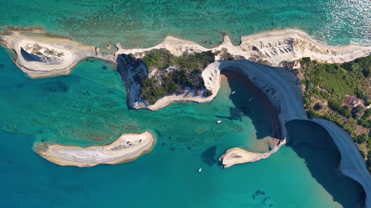 Vista aerea con drone dall'alto delle scogliere bianche di Capo Drastis, baie e mare turchese nell'isola di Corfù, Grecia