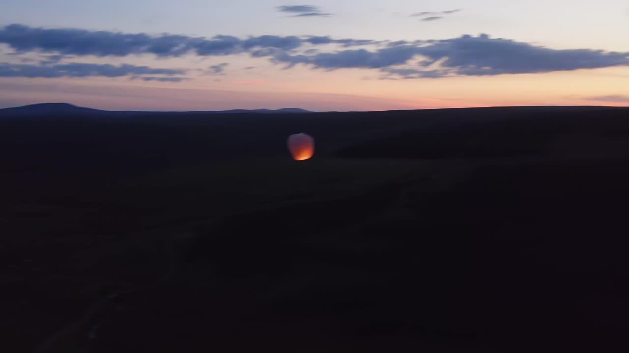 Sunrise drone shot of a sky lantern over peat moor on the Isle of Lewis