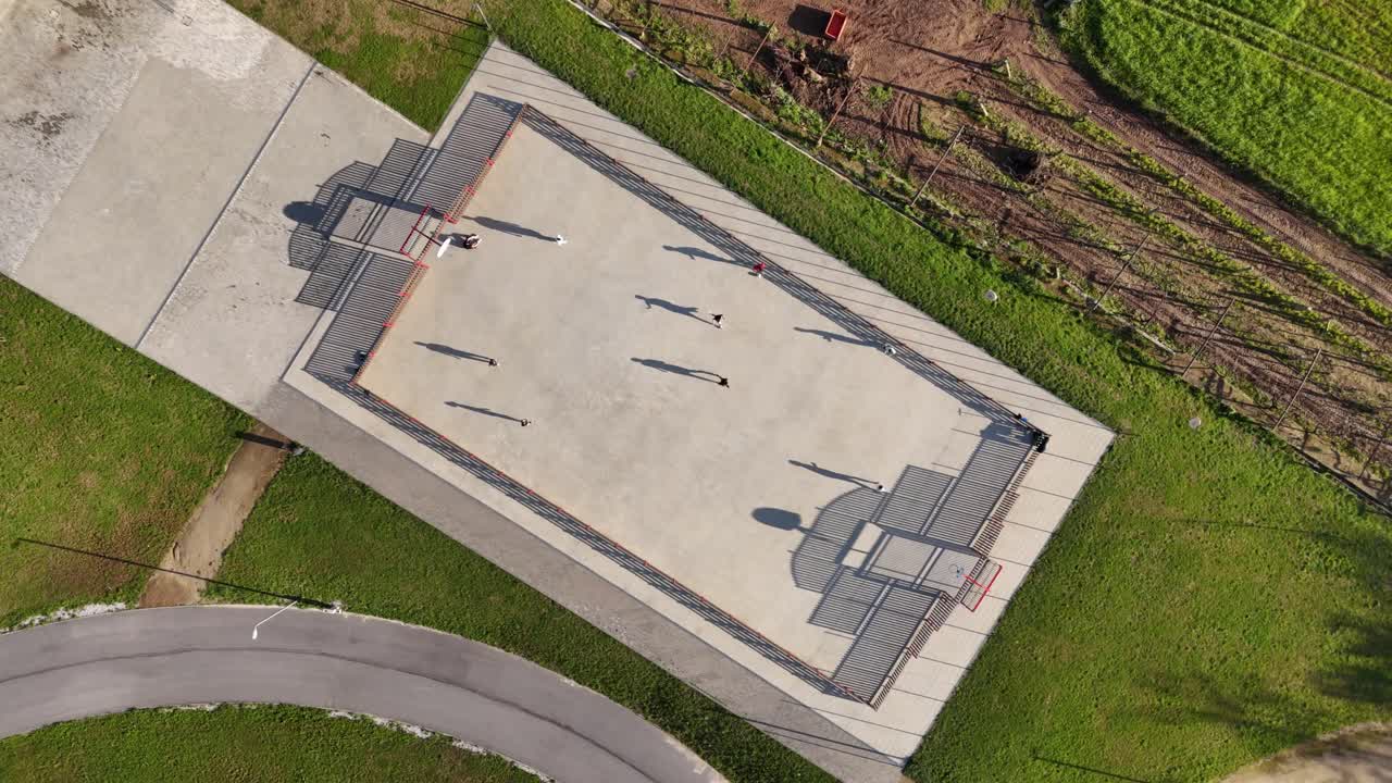 Aerial view of people playing soccer on the concrete field