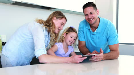 niña pequeña usando una tableta digital con sus padres