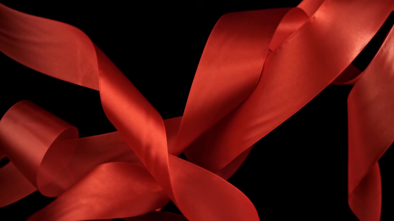 Elegante rote Satinbänder vor schwarzem Hintergrund
