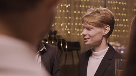 Close-Up-View-Of-Group-Friends-Wearing-Stylish-Clothes-While-Talking-And-Holding-Champagne-Glasses-At-New-Year's-Party