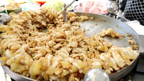 stirring and frying dumplings in a huge skillet.