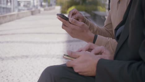 hombres de negocios multiétnicos trabajando con teléfonos inteligentes al aire libre