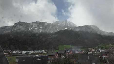 Time-Lapse-Of-Misty-Clouds-Over-High-Rise-Mountains-And-Cottages-In-Rural-Area,-Switzerland