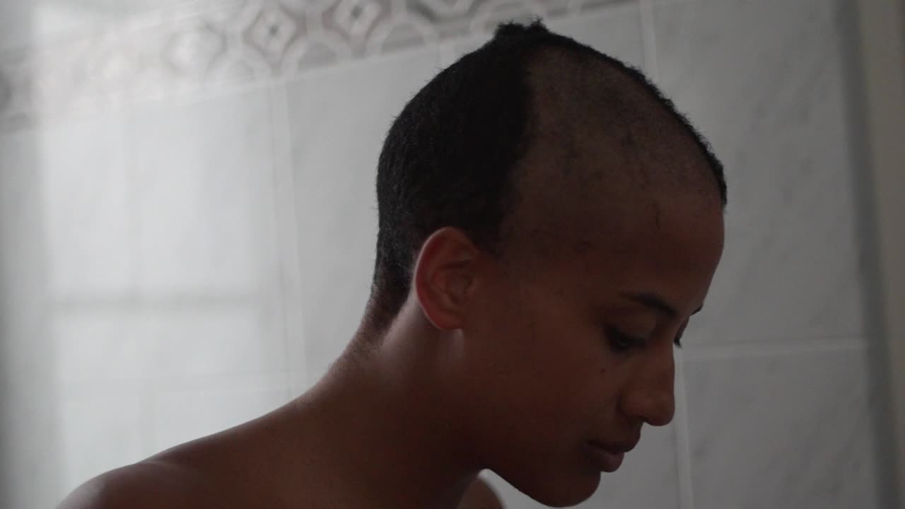 mujer negra recortando el cabello en casa