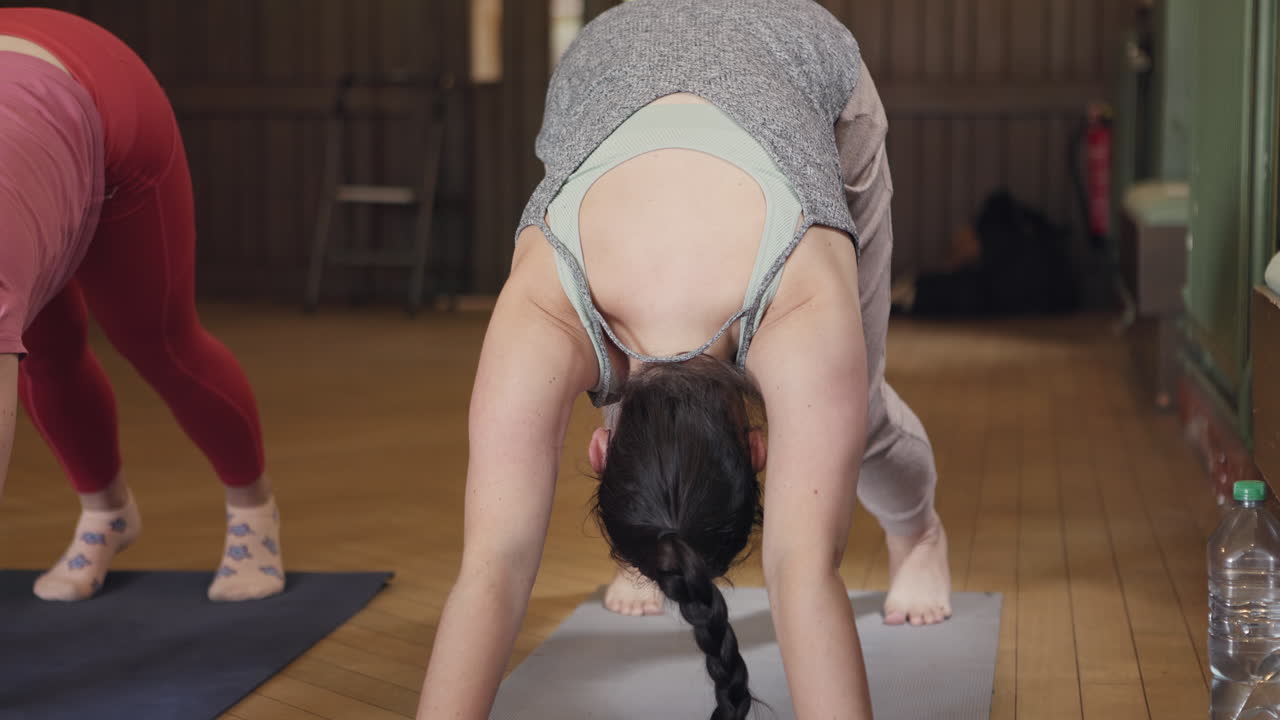 Yoga class practicing downward dog pose