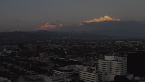 Gorgeous-aerial-fly-over-Los-Angeles-with-colorful-clouds-in-the-distance-during-sunset