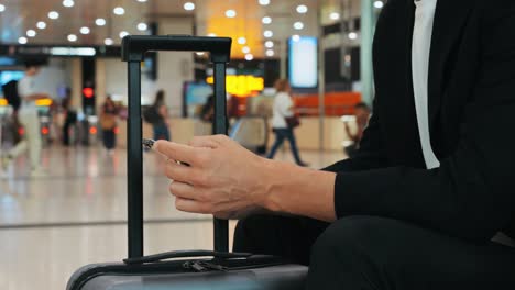 businessman uses laptop, waiting for a flight in airport terminal or train station, traveling entrepreneur working online on computer sitting in a boarding lounge of airline hub with airplanes