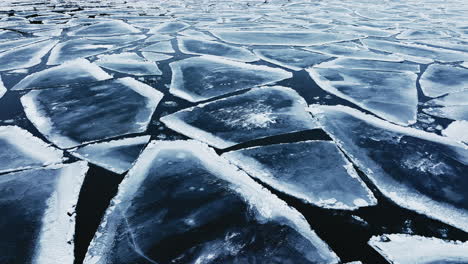 drone shot panning around showing huge chunks of frozen ice in lake michigan