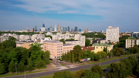 peach coloured apartment building beside road with downtown warsaw cityscape in background