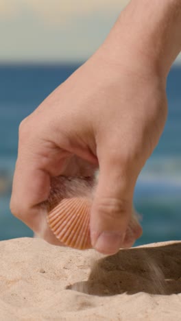 Vertical-Video-Summer-Holiday-Concept-Person-Collecting-Shells-Starfish-On-Sandy-Beach-Against-Sea-Background