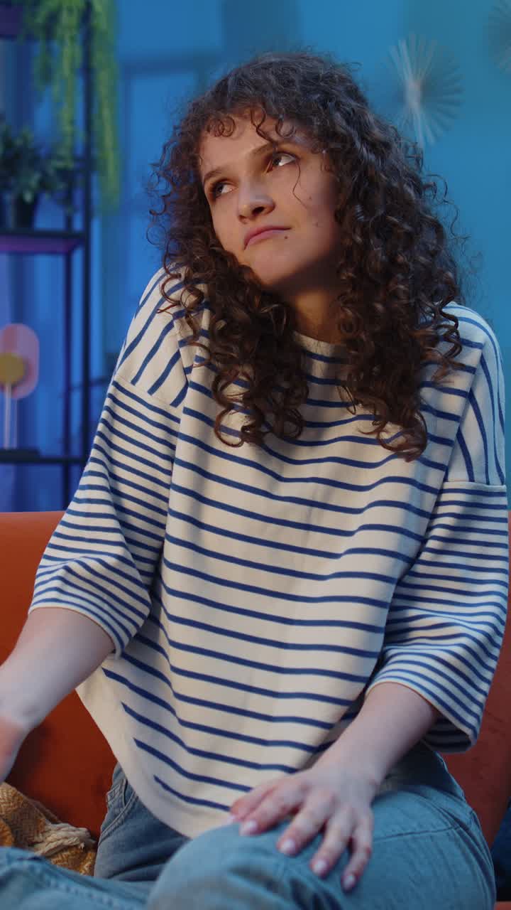 Giovane donna confusa che si sente imbarazzata per una domanda ambigua, piena di dubbi e senza idee, a casa.