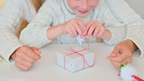 female hands decorate and color a candy cane made of paper using a marker pen