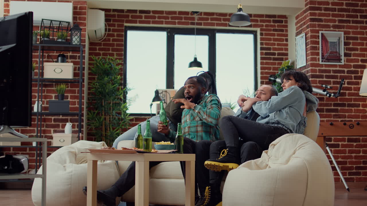 Diverse people getting scared watching horror movie on television