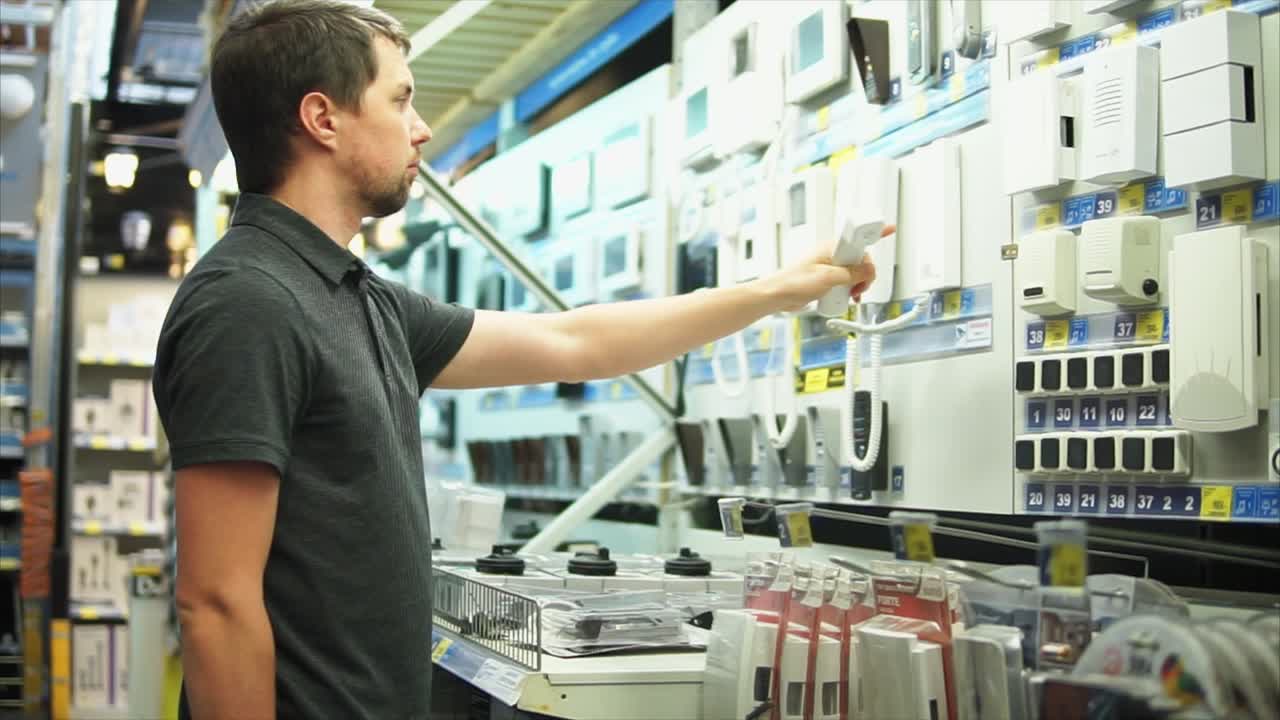 Man browsing intercom systems at a home improvement store