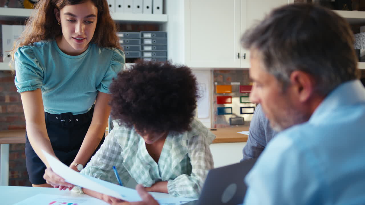 equipo de negocios masculino y femenino con computadora portátil reuniéndose en una oficina moderna