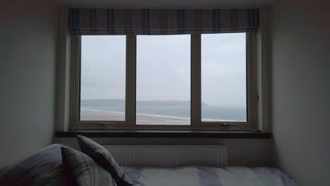 Raindrops-Falling-against-a-Window-with-an-Ocean-View-and-a-Single-Bed-in-the-Foreground