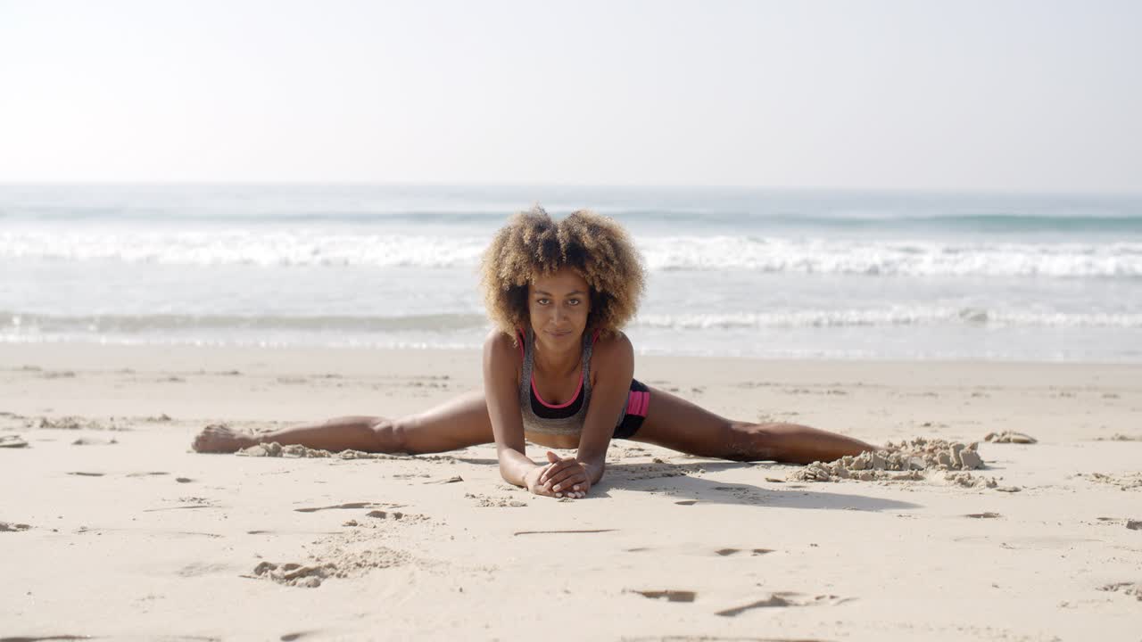 mujer en posición de yoga en la playa