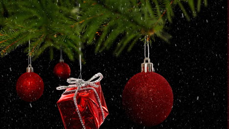 Animation-of-snow-falling-over-hanging-baubles-and-christmas-gifts-on-a-branch-on-black-background