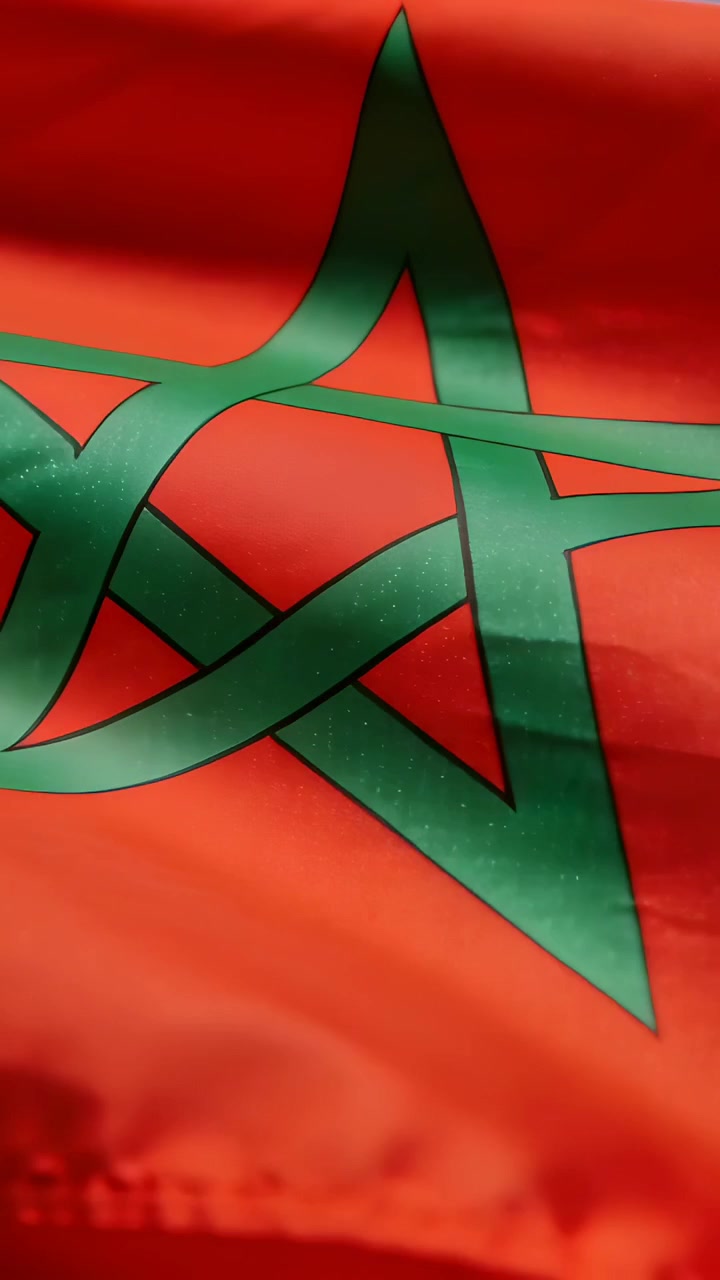 Video verticale: Bandiera rossa increspata con una stella verde che si piega e si allunga per la brezza all'aperto.