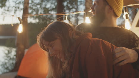 pareja alegre charlando y riendo en el campamento