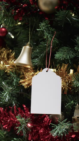vertical video of christmas tree withdecorations and white tag with copy space