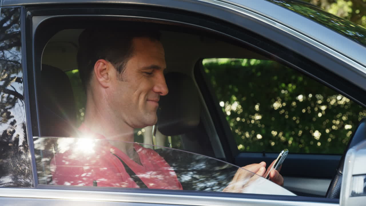 hombre usando teléfono móvil en el asiento delantero del coche