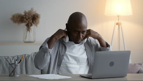 man working on a laptop with headphones