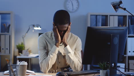 young tired man working at the laptop in the office at night