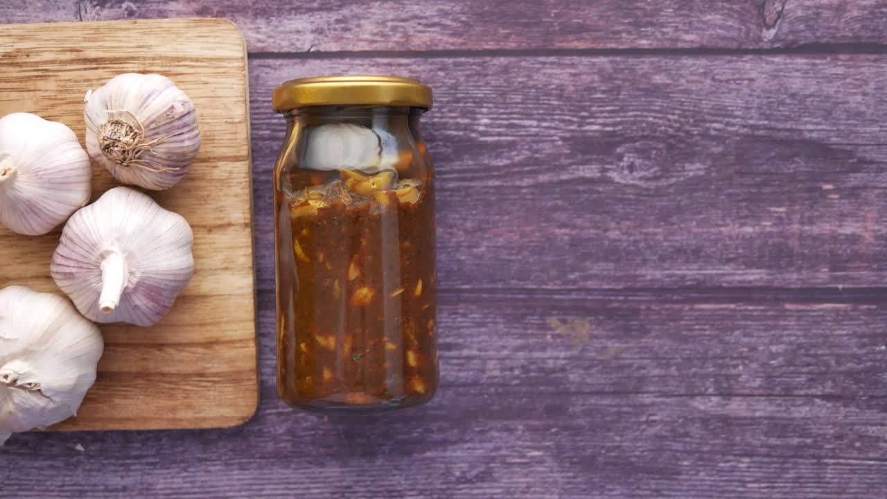 Homemade garlic pickle in a glass jar on table ,
