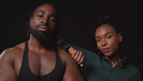 close up studio portrait of determined male and female athletes training in fitness clothing shot against black background 1