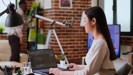 Asian-freelancer-woman-works-on-programming-code-in-a-modern-office