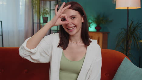 Happy-cheerful-young-woman-looking-approvingly-at-camera-showing-ok-gesture,-positive-like-sign