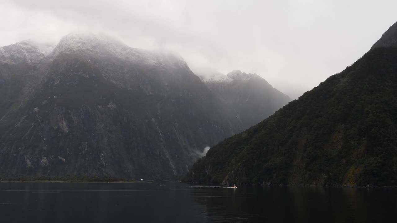 Small boat sailing at Milford Sound (Piopiotahi), Fiordland National Park on the South Island of New Zealand.