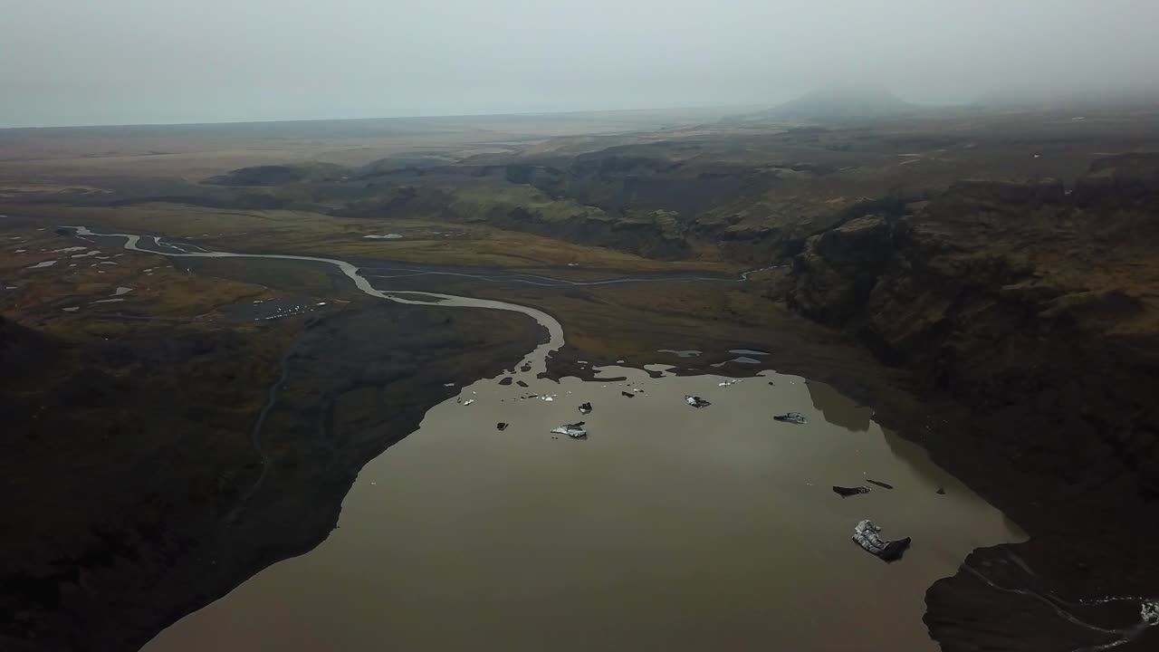 vista aérea del paisaje del agua que fluye del glaciar sólheimajökull, islandia, en verano