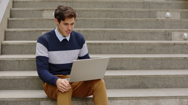 Uomo che lavora al computer portatile sulle scale