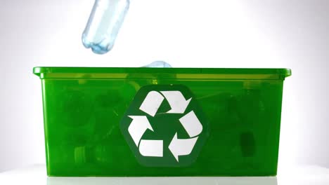 botella cayendo en una caja verde