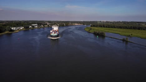 front view of container ship cruising across the river