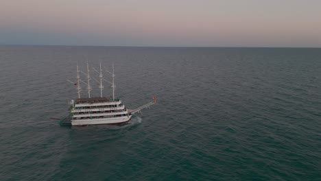 Vista-Aérea-De-Un-Velero-De-Varios-Niveles-Con-Mástiles-Navegando-A-Través-Del-Tranquilo-Y-Tranquilo-Atardecer-Del-Mar-Mediterráneo.