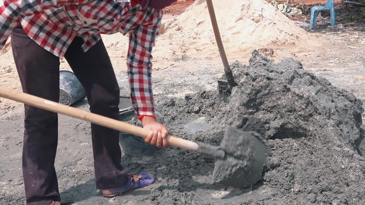trabajador mezclando hormigón en un día soleado