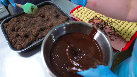 coating sweets with chocolate and then with cocoa sprinkling. handicraft manufacturing of chocolate desserts. close up.