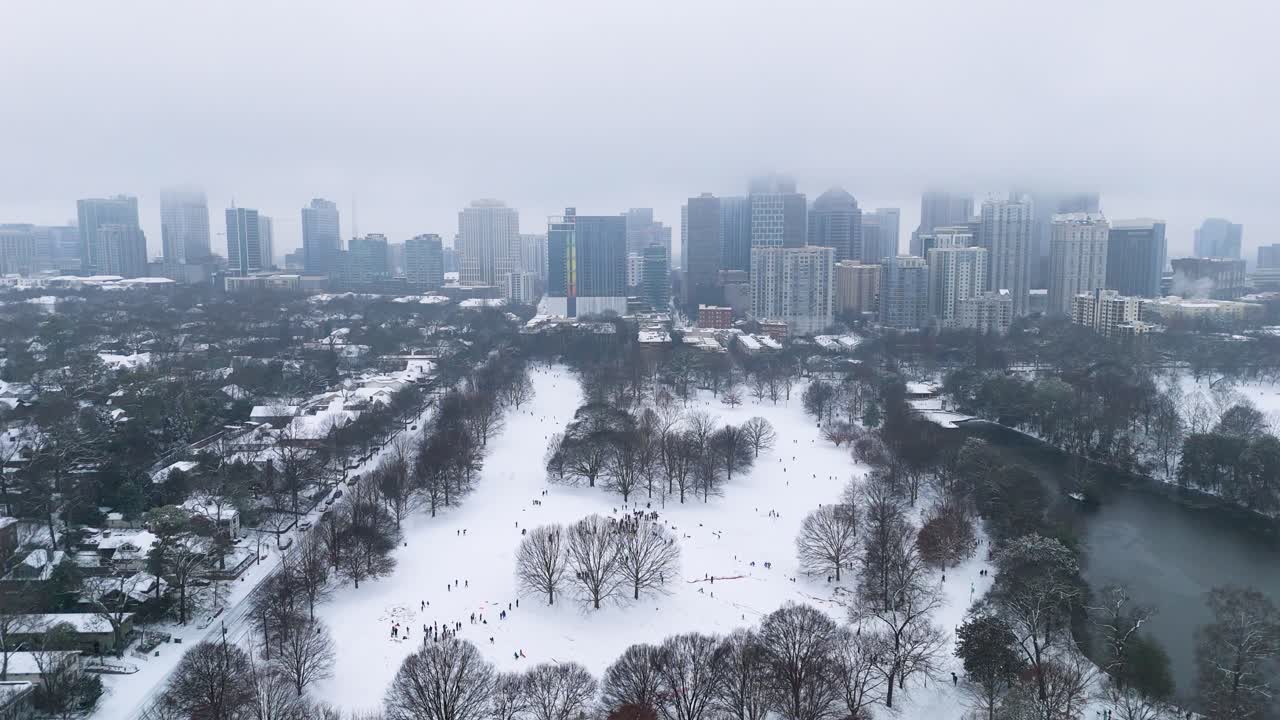 Aerial push in on a snow covered Piedmont Park and Midtown Atlanta, Georgia.