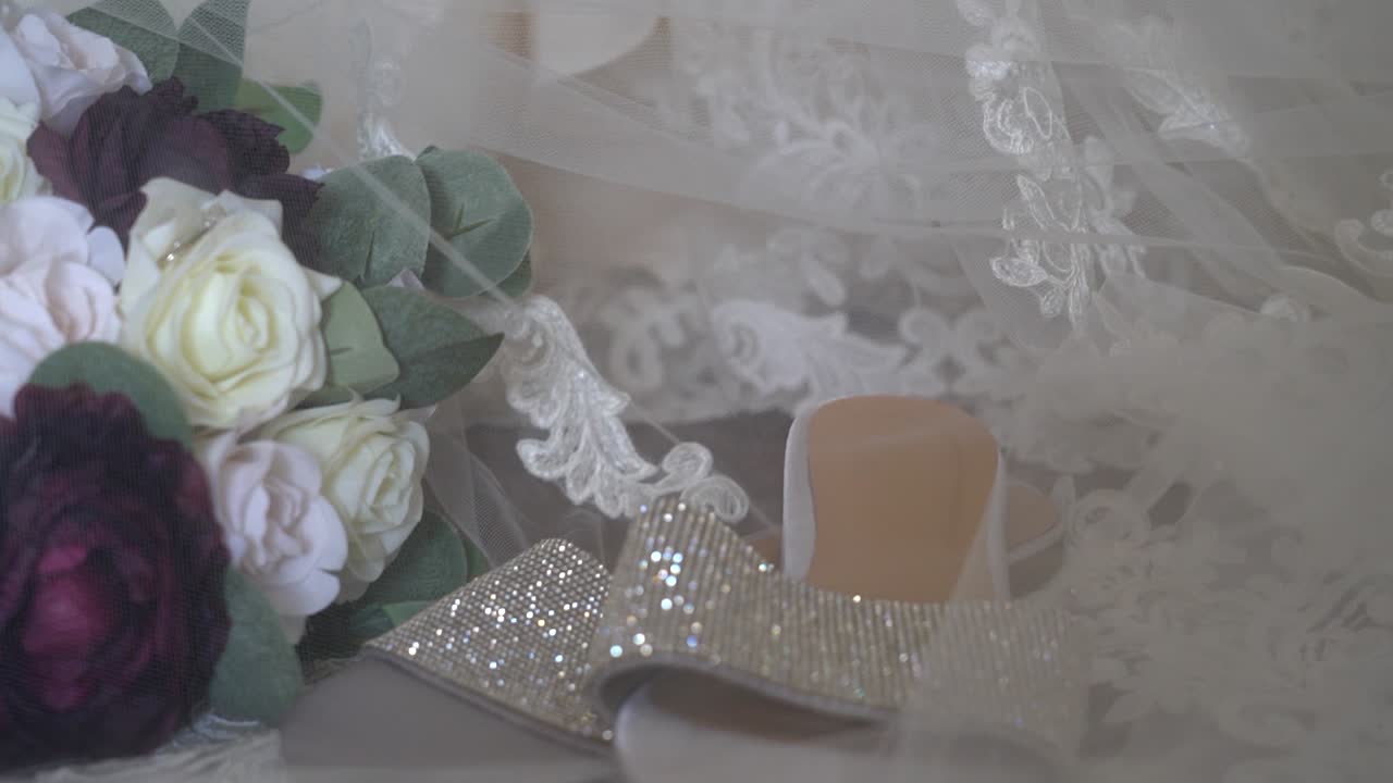 Gorgeous bridal detail layout with the vale covering overtop and the dress as the background