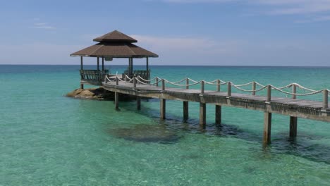 a gazebo on the end of a pier in the open ocean in asia crop pan