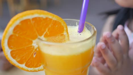 niño bebiendo jugo de naranja al aire libre