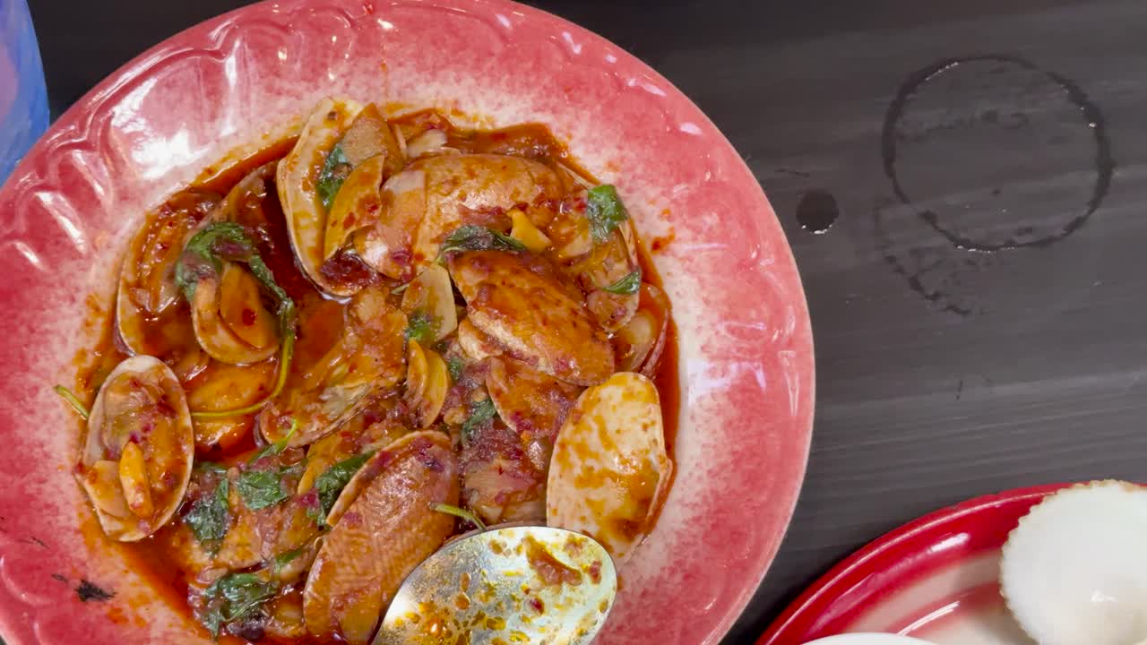 A sequence of overhead shots shows Thai seafood dishes, spicy minced pork salad, and Miang Kham being prepared and served under bright lighting on a dark tabletop