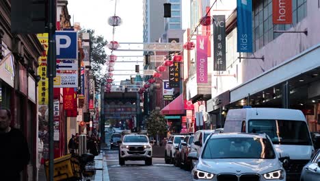 vehicles and pedestrians in bustling chinatown street